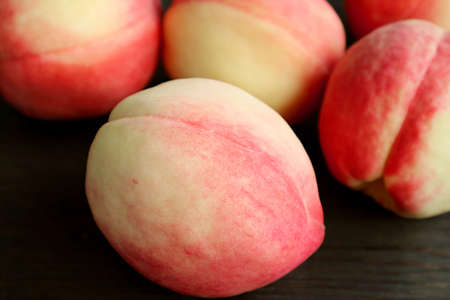 Closeup a Fresh Ripe Peach with Blurry Another on Black Wooden Backgroundの写真素材