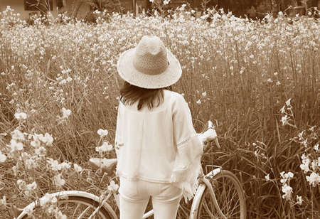Sepia Image of a Woman with Her bicycle in the Parkの写真素材
