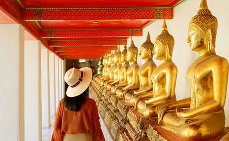 Female Visiting the Cloister with Large Group of Seated Buddha Images in Wat Pho or Temple of the...