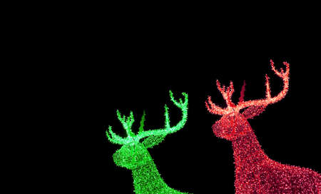 Vivid Green and Red Illuminated Christmas Reindeer Shaped Outdoor Decoration Lights on Night Sky Backgroundの写真素材