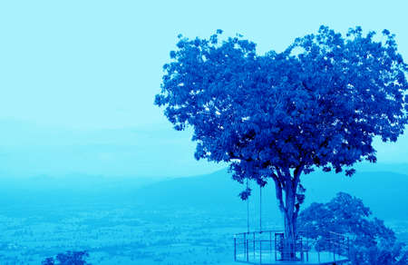 Pop Art Surreal Style Heart Shaped Tree on Cloudy Sky in Vibrant Blue Color Toneの写真素材