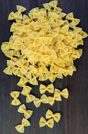 Pile of Farfalle Pasta Also Known As Bow-tie Pasta on Black Wooden Background
