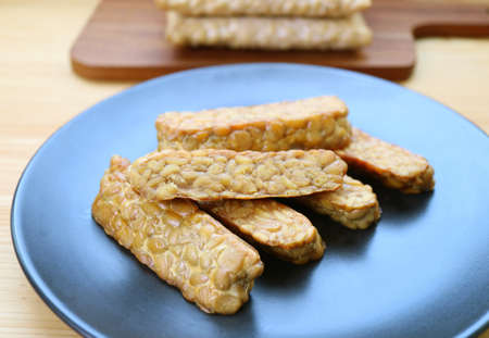 Plate of pan fried Tempeh, a high plant-based protein source for whole foods plant-based dietの写真素材
