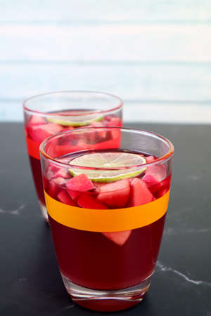 Two Glasses of Chilled Red Wine Sangria Isolated on Black Tableの写真素材