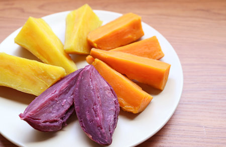 Plate of three different color steamed sweet potatoes, for a concept of good source of healthy carbsの写真素材