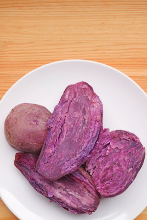 Plate of Delectable Steamed Unpeeled Purple Sweet Potatoes Showing Vivid Color Fleshの写真素材