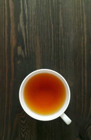 A Cup of Japanese Roasted Barley Tea or Mugicha Isolated on Dark Brown Wooden Tableの写真素材
