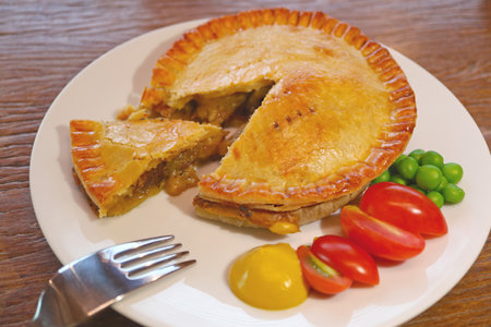 A Plate of Delectable Golden Brown Beef Pie Served on Wooden Table