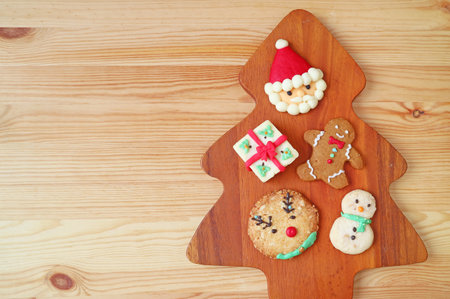 Top View of Assorted Christmas Cookies on Pine Tree Shaped Wooden Breadboard with Copy Spaceの写真素材