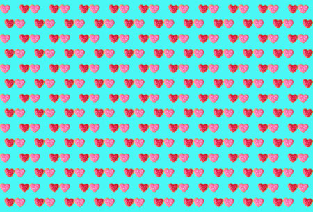 Pattern of pair of red and pink heart shaped royal icing cookies on arctic blue background