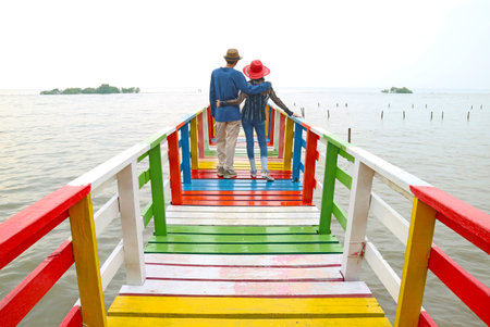 Couple Relaxing Together on Waterfront Colorful Wooden Boardwalkの写真素材