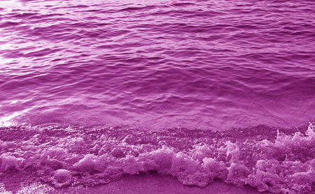Pop art surreal style of purple colored waves splashing on the beachの写真素材