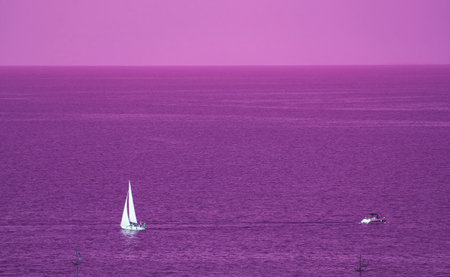 Surreal Pop Art Image of White Sail Yacht in Sailing on the Purple Ocean and Skyの写真素材