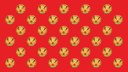 Pattern of Reindeer Shaped Christmas Cookies on Red Backgroundの写真素材