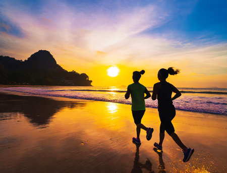 Silhouette of a couple jogging on the morning  beachの素材