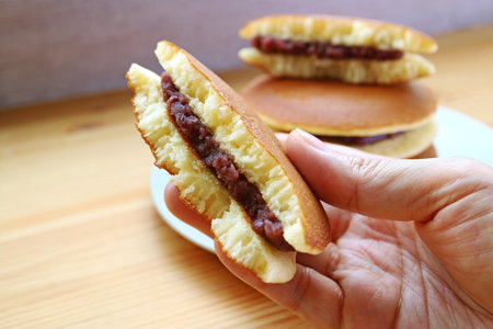 Hand Holding Delectable Split Dorayaki, a Famous Japanese Pancakeの写真素材