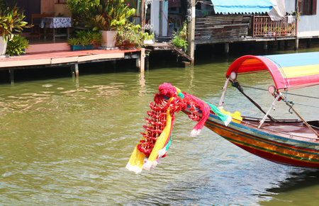Flower garlands hung on Thai long tail boat prow for the offering to Mae Ya Nang Goddessの写真素材