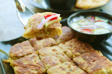 Closeup of Mouthwatering Minced Beef Stuffed Roti Mataba with Flavorful Ajad Sauceの写真素材