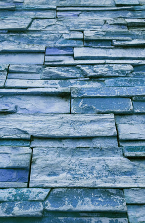 Low Angle View of Gradient Blue Colored Rough Stone Blocked Wallの写真素材