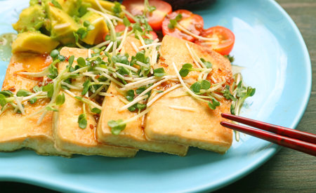 Closeup of Delectable Grilled Tofu and Salad, Garnished with Kaiware Daikon Microgreensの写真素材