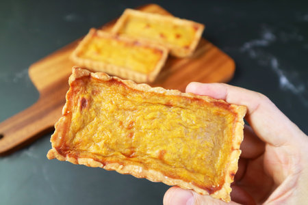 Closeup of Hand Picking a Mouthwatering Pumpkin Tartlet