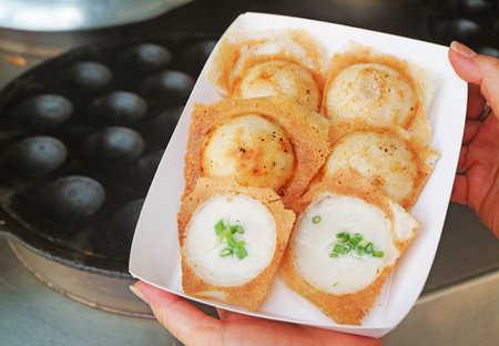 Sweet and fragrant Thai coconut milk pancakes called Kanom Krok, one of the popular street food in Thailandの写真素材