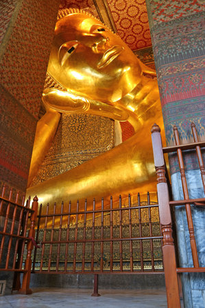 Gigantic Reclining Buddha Image with Spectacular Interior of Wat Pho Temple Located in Phra Nakhon District of Bangkok, Thailandの写真素材