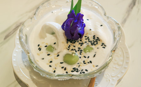 Tasty glutinous rice ball dumpling with shredded coconut fillings in coconut milk called Khanom Kho Katiの写真素材