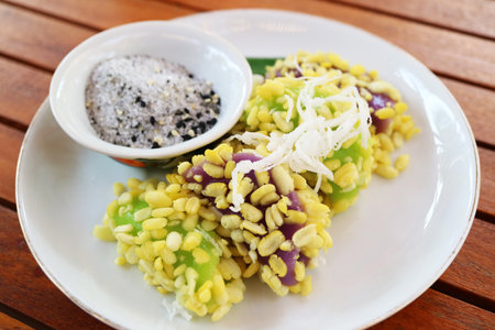 Delectable Thai Dessert Called Khanom Tua Pap, Sticky Rice and Mung Beans Dumplings Sprinkled with Sugar and Sesame Seedsの写真素材