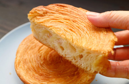 Hand Picking a Delectable Spiral Shaped Supreme Croissantの写真素材