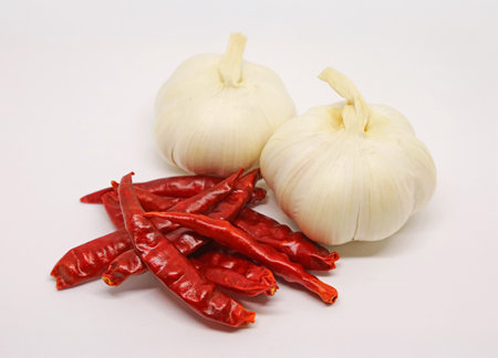 Pair of Garlic Bulbs and Heap of Dried Red Chili Peppers Isolate on White Backgroundの写真素材