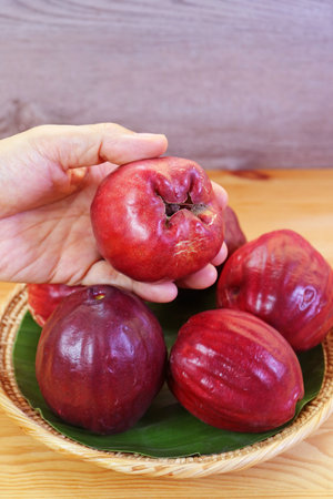 A Basket of fresh ripe deep red Malay apples called Chompu Mameaw in Thailandの写真素材