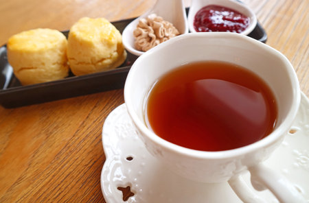 Closeup of a Cups of Hot Tea with Plate of Scones in the Backdropの写真素材