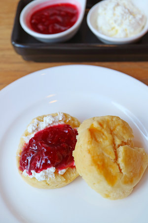 Mouthwatering Scone Topped with Whipped Cream and Raspberry Jamの写真素材