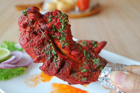 Hand Picking a Piece of Flavorful Tandoori Chickenの写真素材