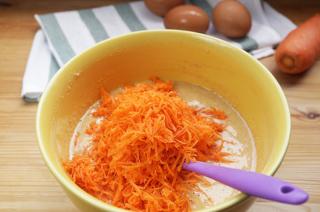 Grated carrot in a bowl of Mixture for baking carrot cakeの写真素材