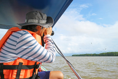 People Photographing the Brahminy Kites Called Red Hawks in Thailand at Bang Chan Fishing Village,...