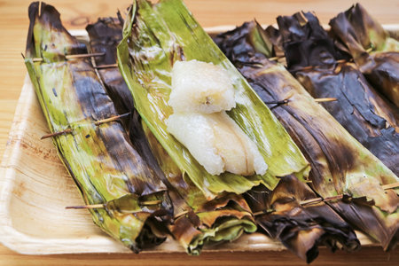 Delectable Charcoal Grilled Thai Sweetened Sticky Rice with Fillings Wrapped in Banana Leaf Called Khao Niao Pingの写真素材
