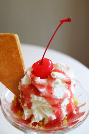 Closeup of Maraschino Cherry Topped on Strawberry Ice Cream Sundae Whipped Creamの写真素材