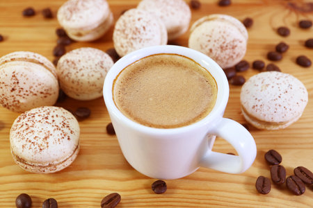 Closeup of a Cup of Espresso with Heap of Delectable Tiramisu Macarons Scattered Aroundの写真素材