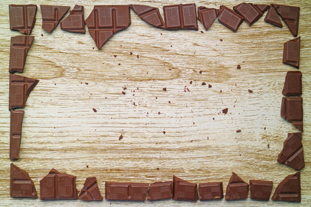 Artistic chocolate chunks frame on wooden background with copy spaceの写真素材