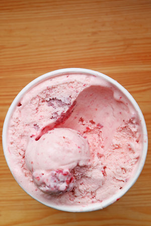 A cup of delectable sweet and tart strawberry ice cream