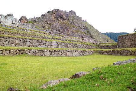 Groups of Visitors Exploring an Iconic Inca Citadel Ruins of Machu Picchu, UNESCO World Heritage Site in Cusco Region of Peru, South Americaの写真素材