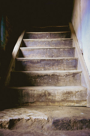 Old wooden traditional style stairs in an abandoned house in Chinaの写真素材