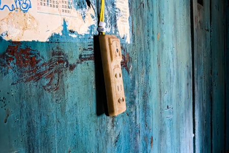 Old asian electric plug on the wall of an old and damaged traditional style empty abandoned house in China, Yunnan, Kunmingの写真素材