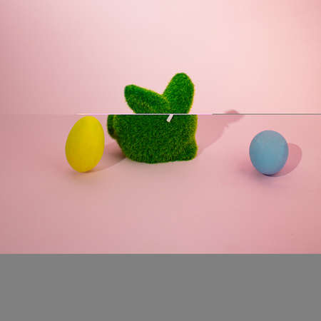 Easter bunny and two Easter eggs on a pink pastel background. Creative minimal concept.の写真素材