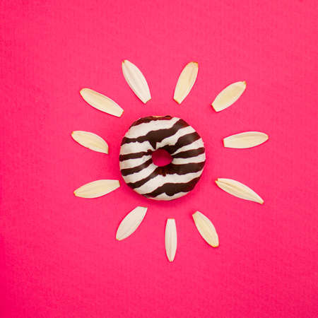 Donut as a spring flower on a pink background. Creative minimal spring idea.の写真素材