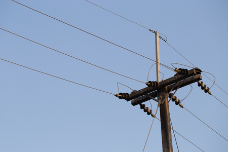 High voltage electricity pole with blue clear sky background