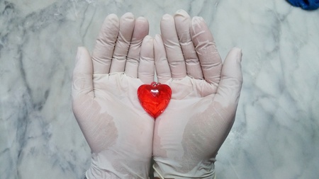 Red and clear heart shape pendants in the hands