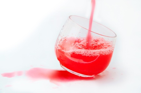 Strawberry juice being poured into a glass splashingの写真素材
